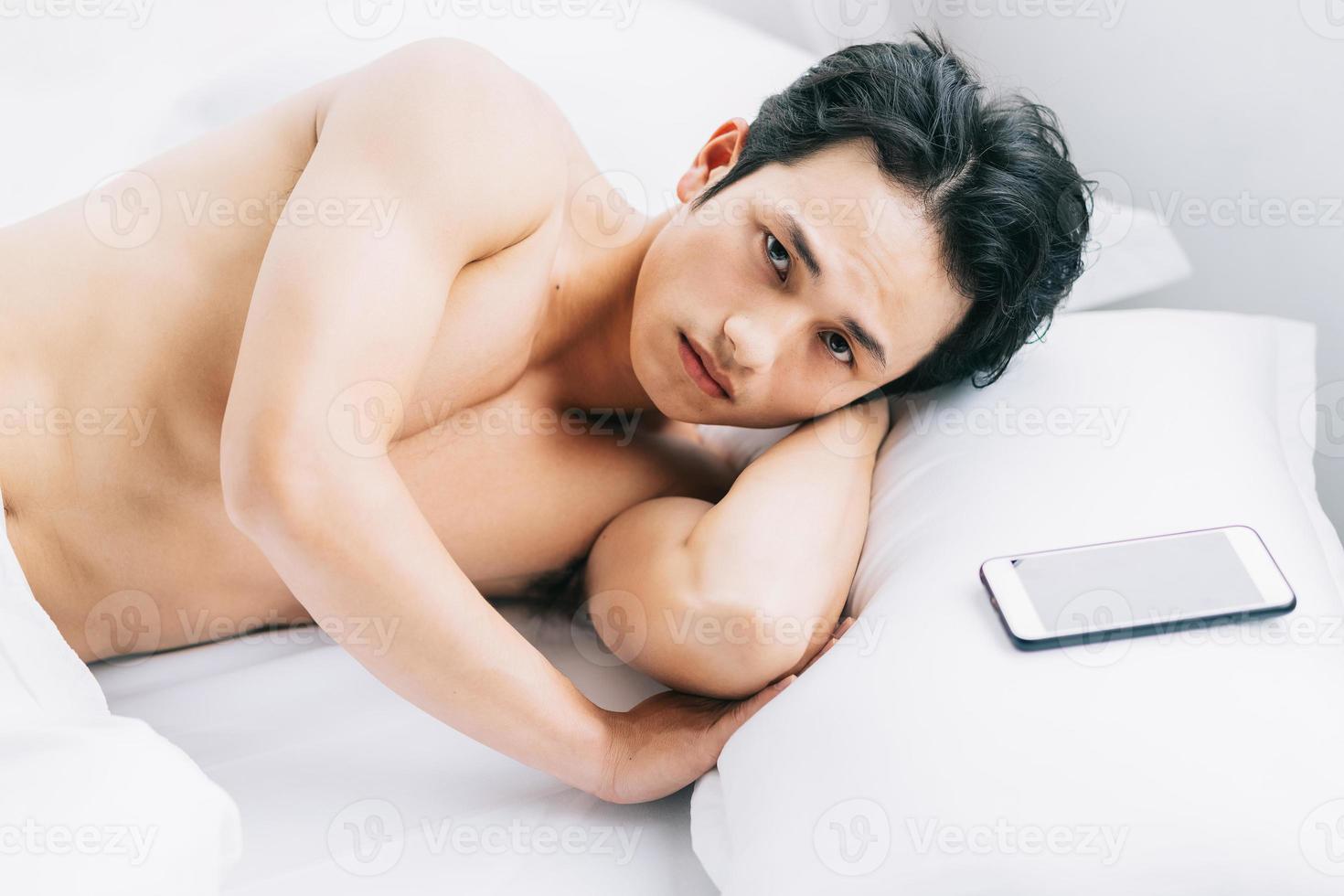 The muscular man is lying on the bed photo