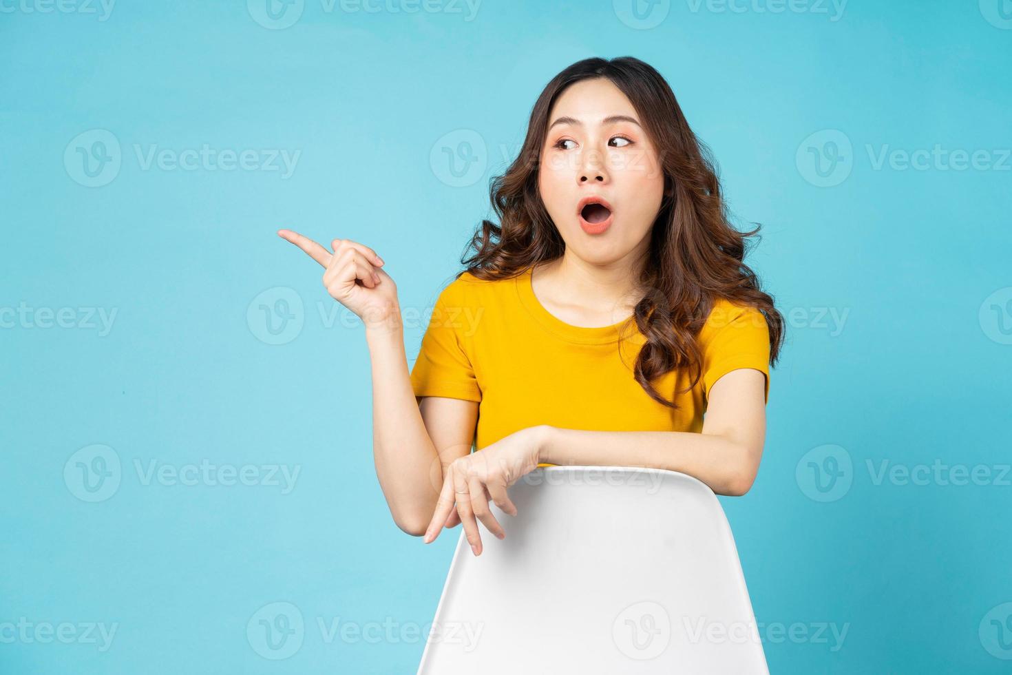 Young girl sitting in chair with gesture and expression on background photo