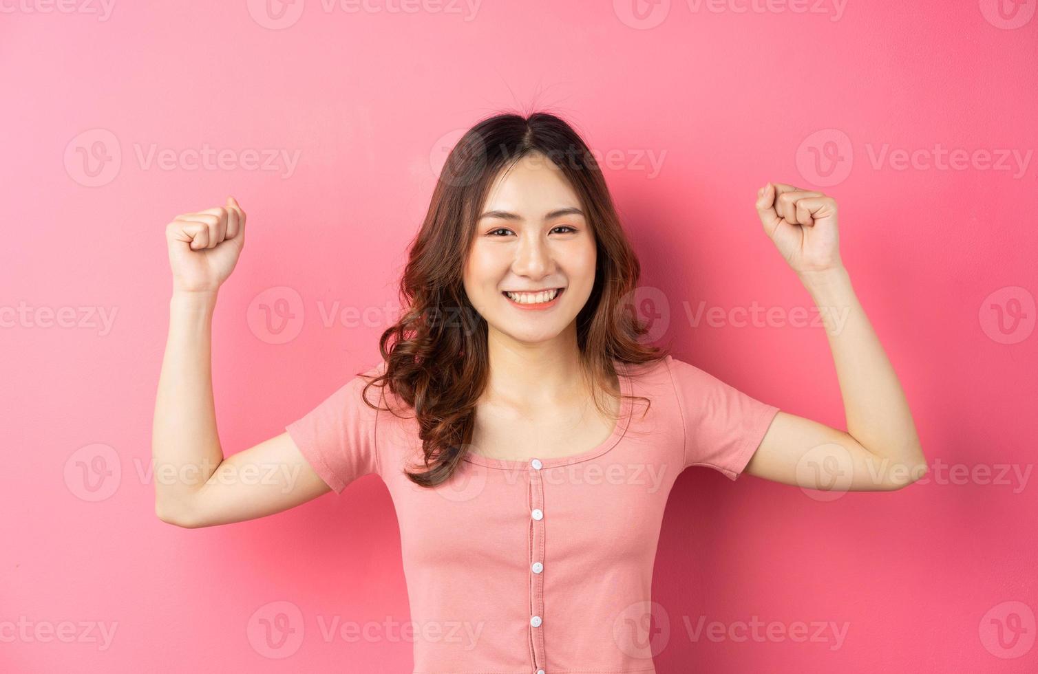 Hermosa joven celebrando la victoria en el fondo foto