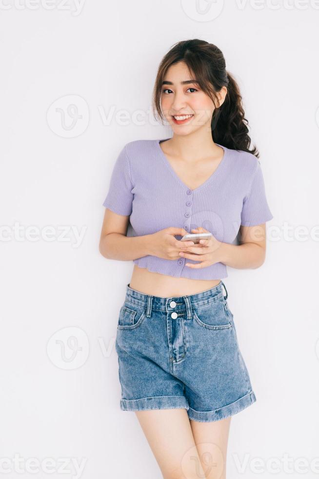 Young Asian woman using smartphone on white background photo
