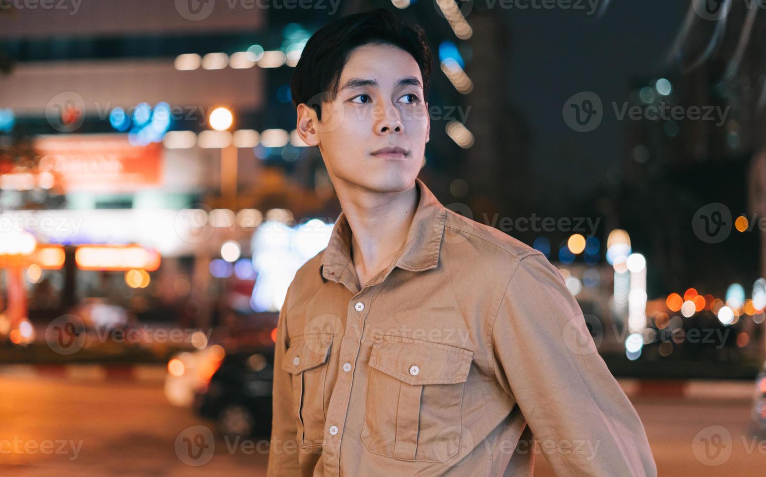 Asian man is walking in the street at night feeling lost photo