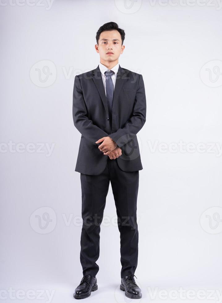 Young Asian businessman standing on white background photo