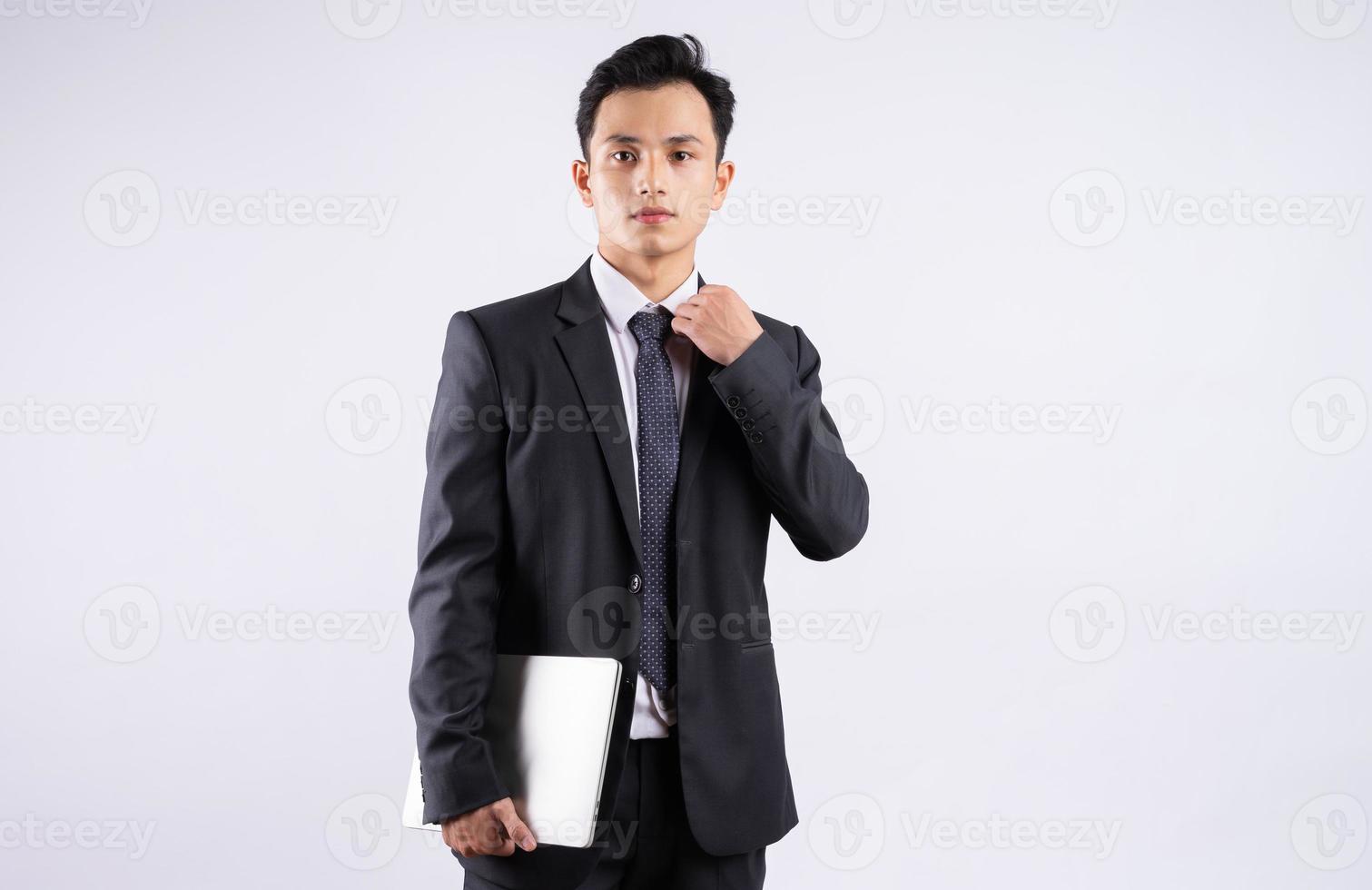 Joven empresario asiático con portátil sobre fondo blanco. foto