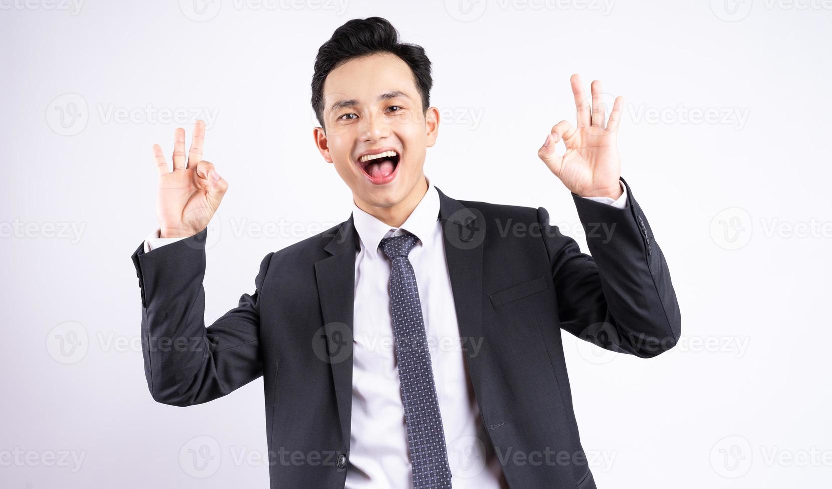 Imagen del joven empresario asiático vistiendo traje sobre fondo blanco. foto