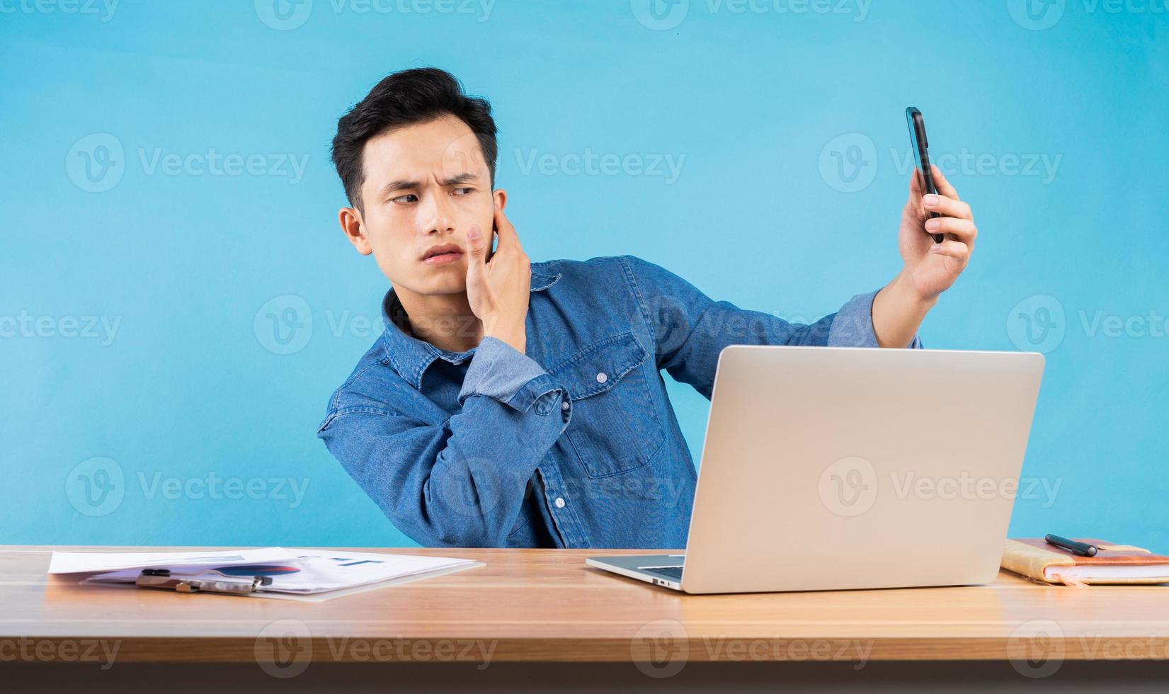 Image of young Asian businessman on blue background photo
