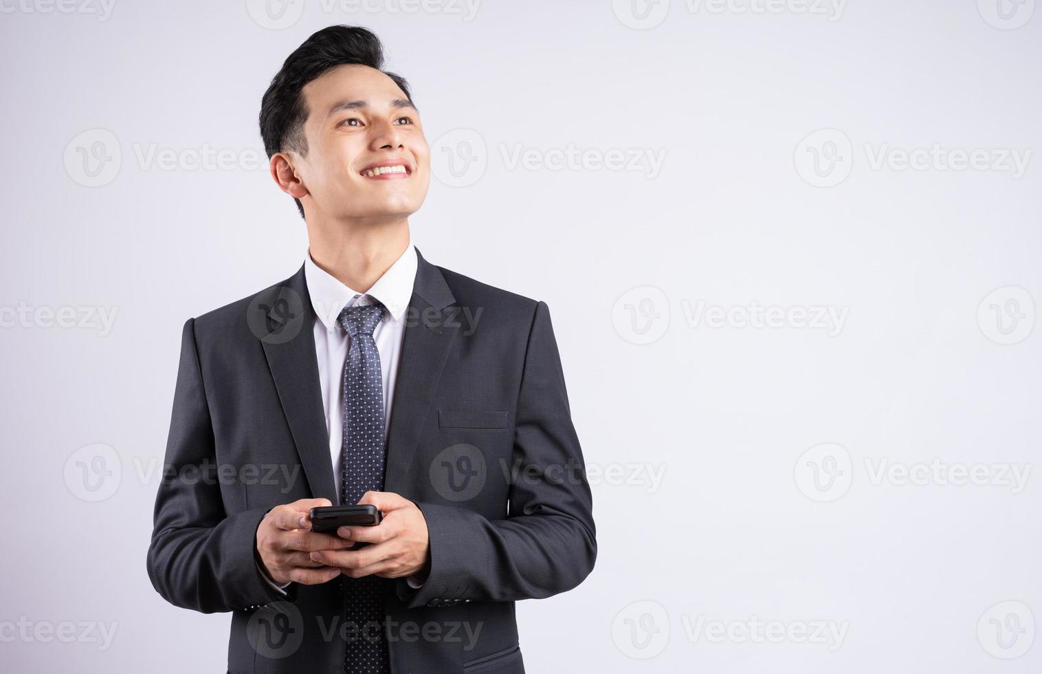 Imagen del joven empresario asiático vistiendo traje sobre fondo blanco. foto