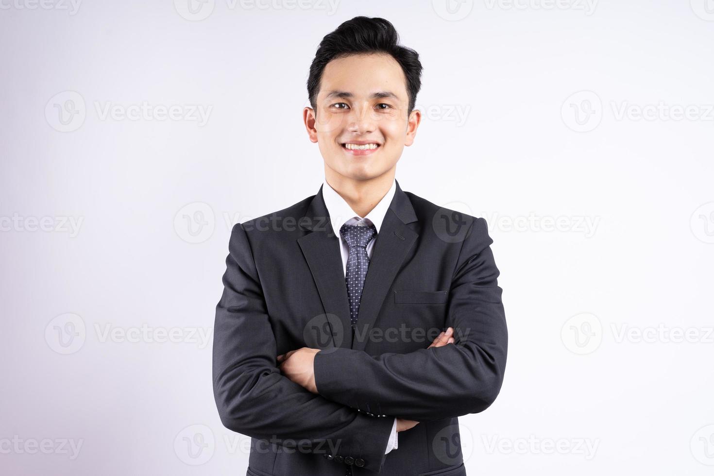 Imagen del joven empresario asiático vistiendo traje sobre fondo blanco. foto