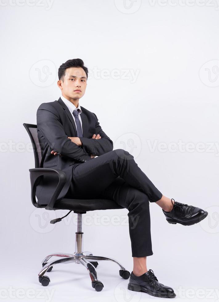 Young Asian businessman sitting on chair on white background photo