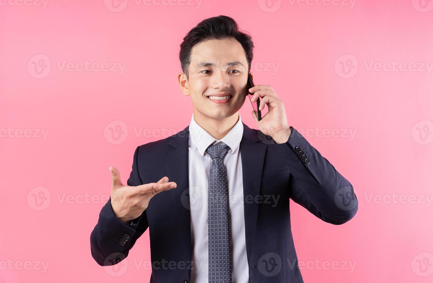 Image of young Asian businessman on pink background photo