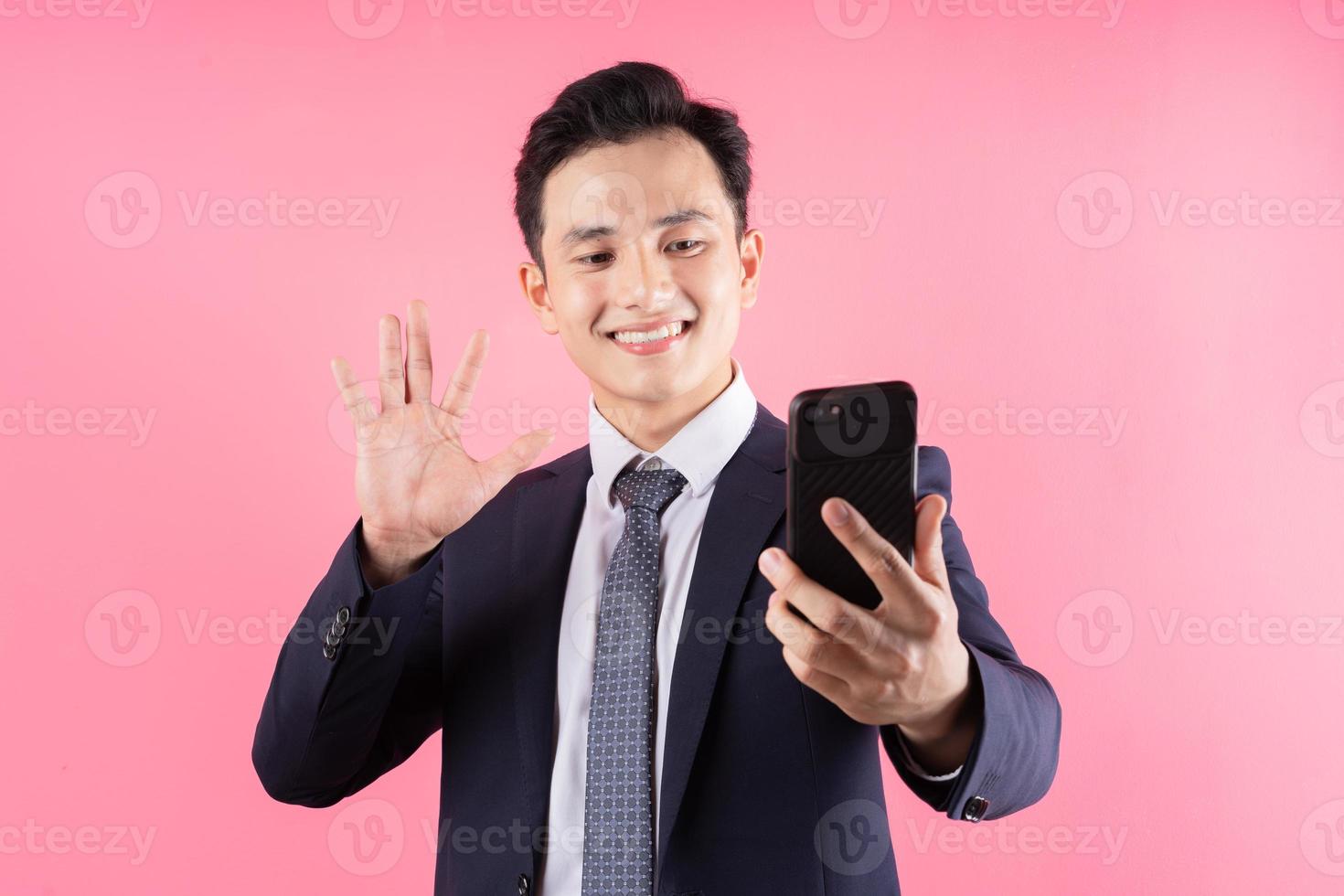 Imagen del joven empresario asiático sobre fondo rosa foto