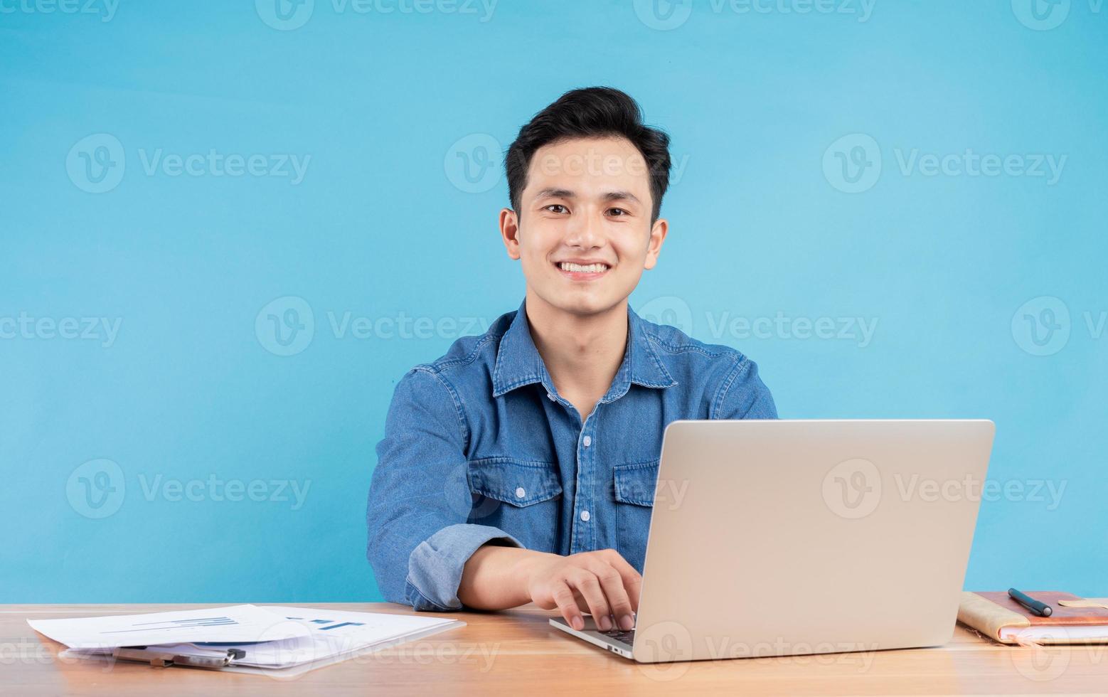 Image of young Asian buisnessman on blue background photo