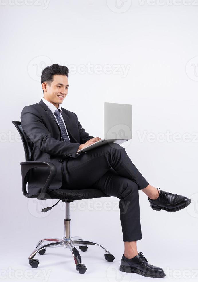 Young Asian businessman sitting on chair on white background photo