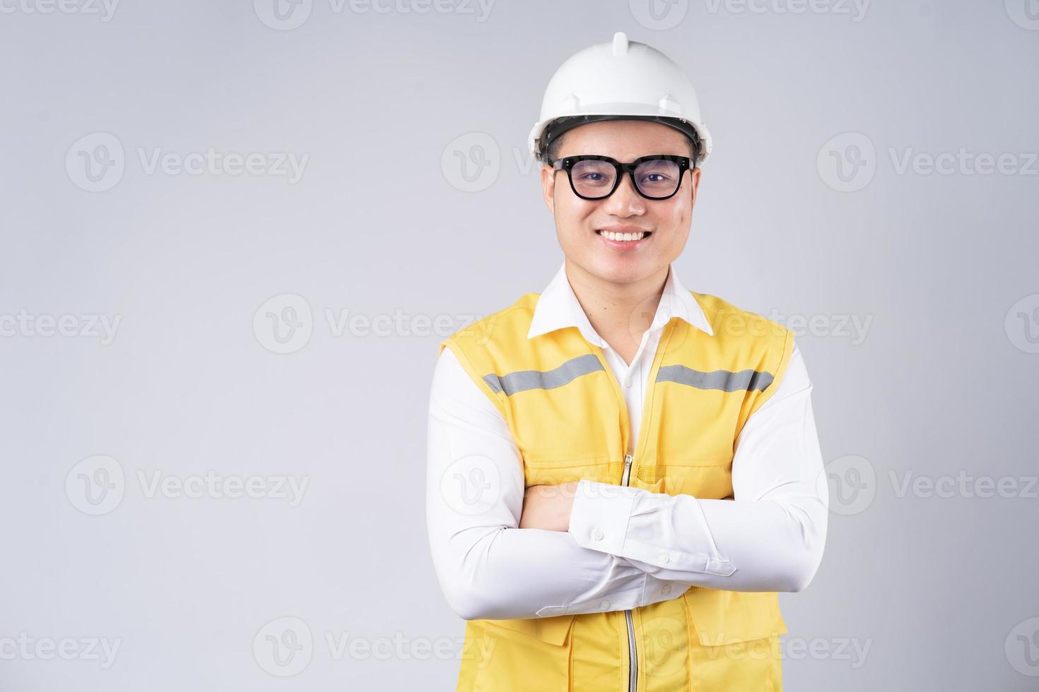 Imagen del ingeniero asiático con una sonrisa sobre fondo gris foto