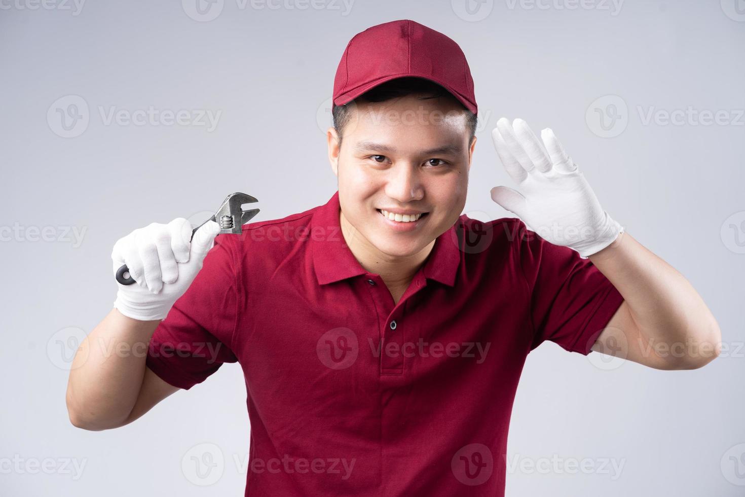 Image of Asian repairman on gray background photo