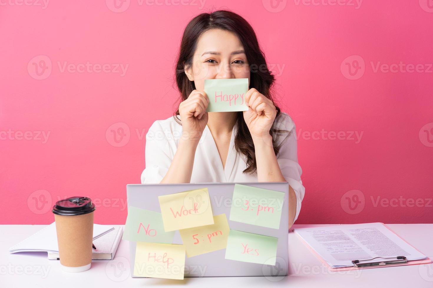 Joven empresaria asiática sentada trabajando con expresión en el fondo foto