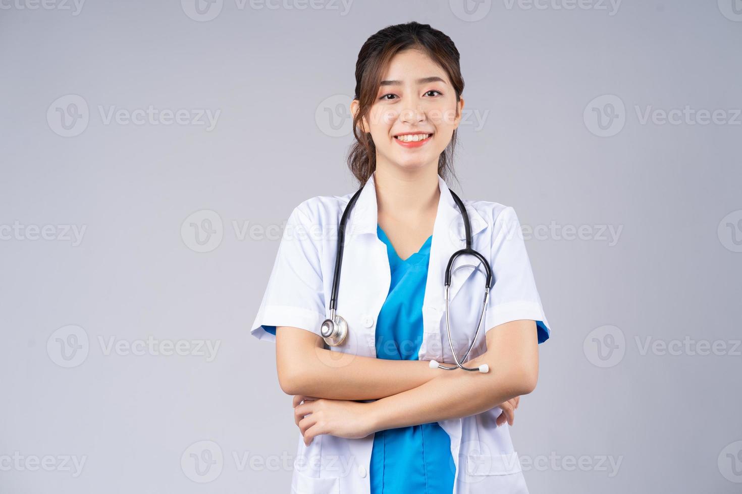 Image of young Asian female doctor on grey background photo