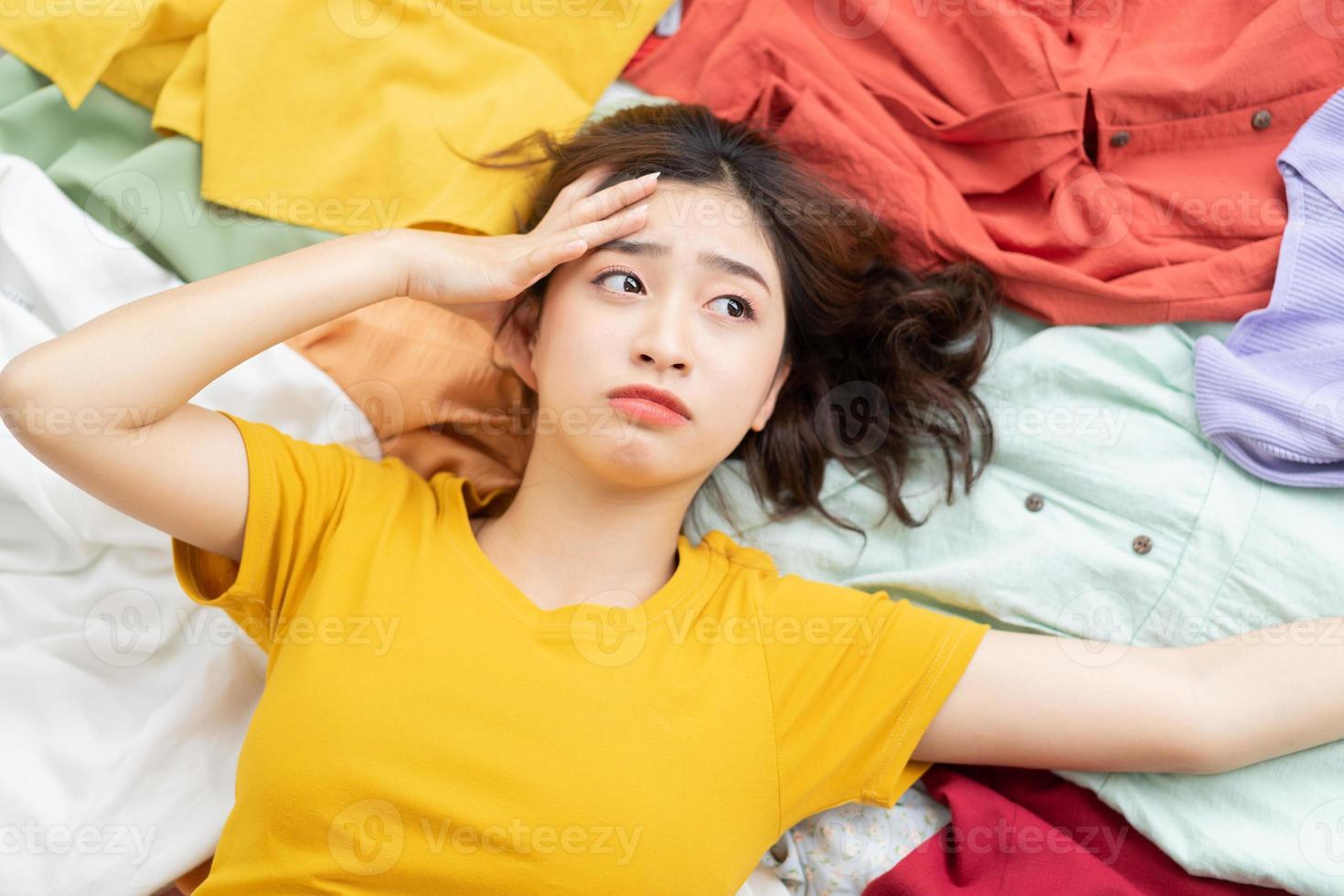 Asian girl stuck in her mess of clothes photo