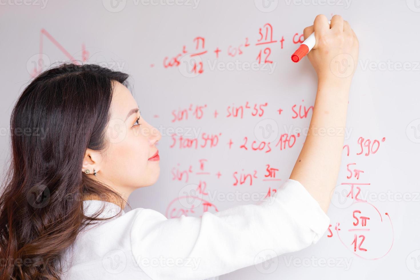 la maestra asiática está reescribiendo la conferencia en el pizarrón foto