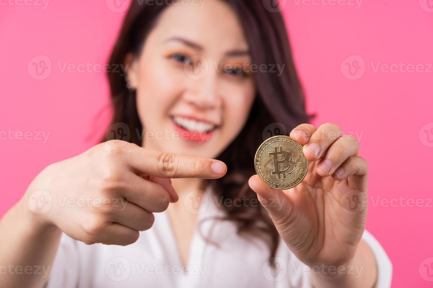 Empresaria asiática sosteniendo bitcoin en su mano foto