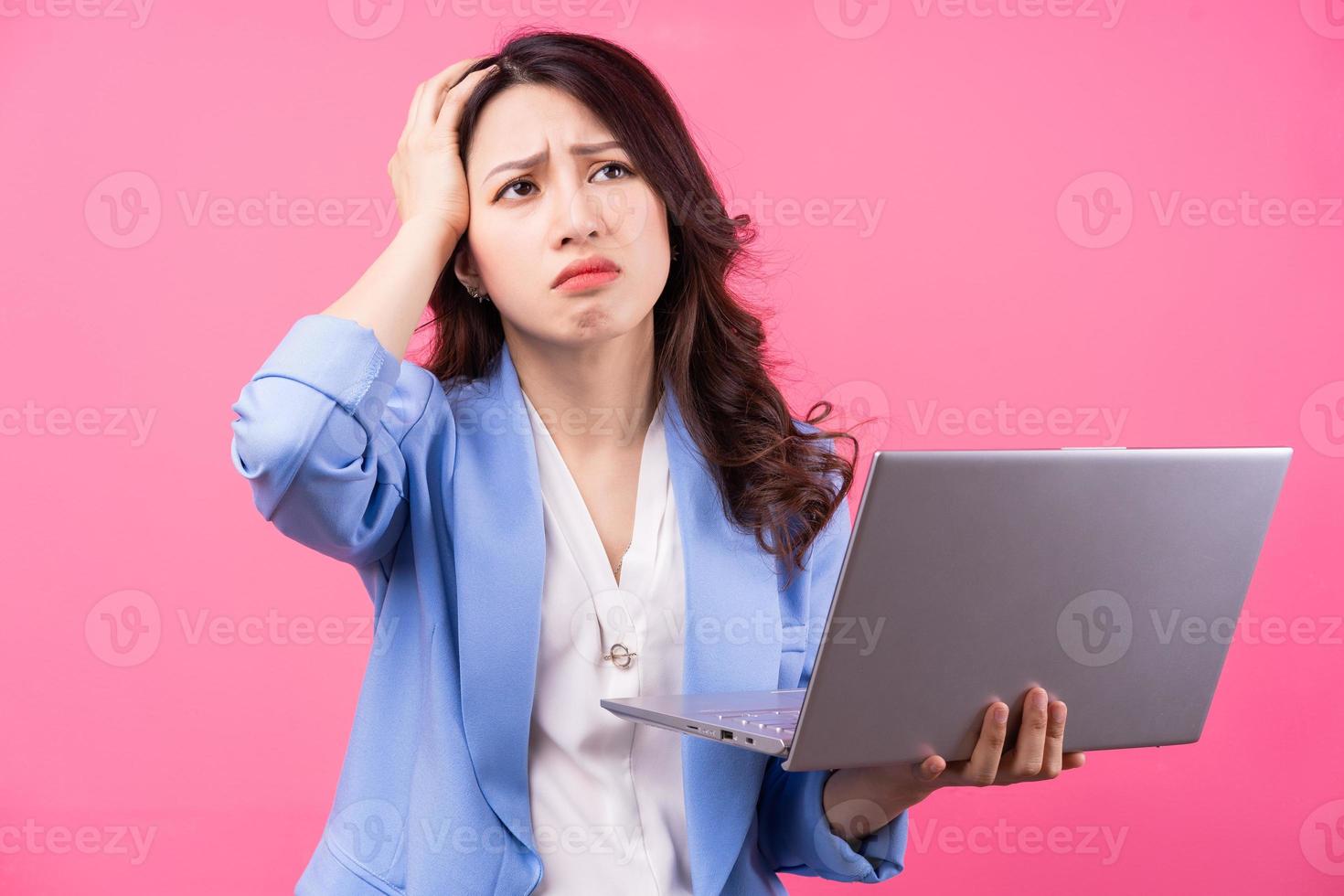 Asian business woman holding laptop on pink background photo