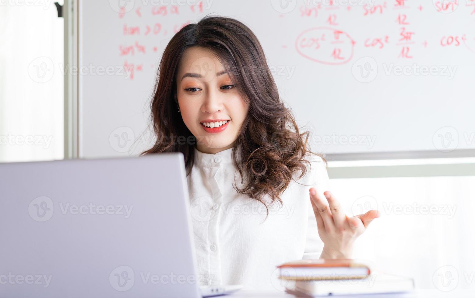 maestra asiática enseñando en línea en casa foto