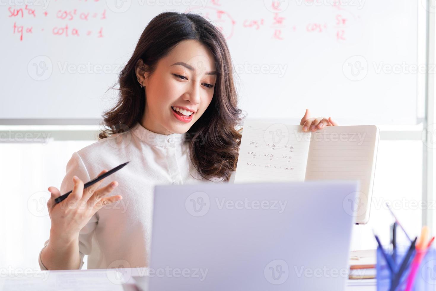 Asian female teacher teaching online at home photo