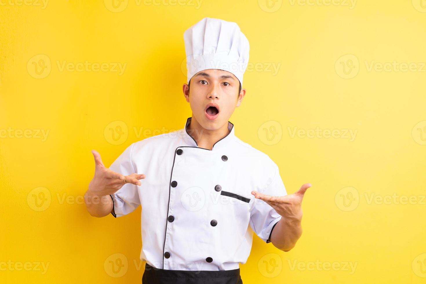 Image of Asian male chef on yellow background photo