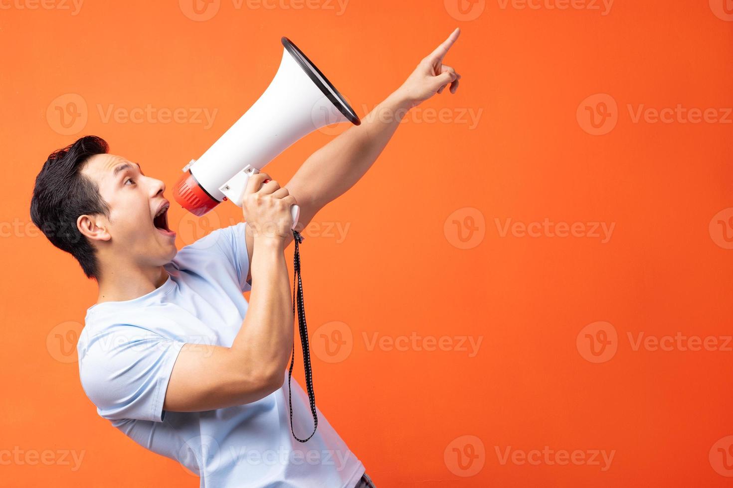 Asian man holding megaphone and shouting photo