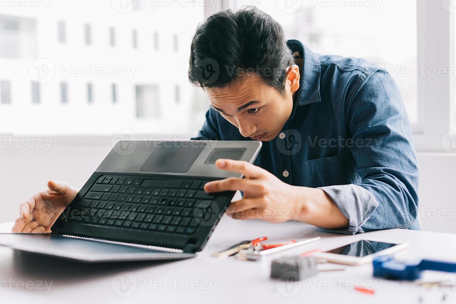 The Asian man was taking out a broken computer to repair it photo