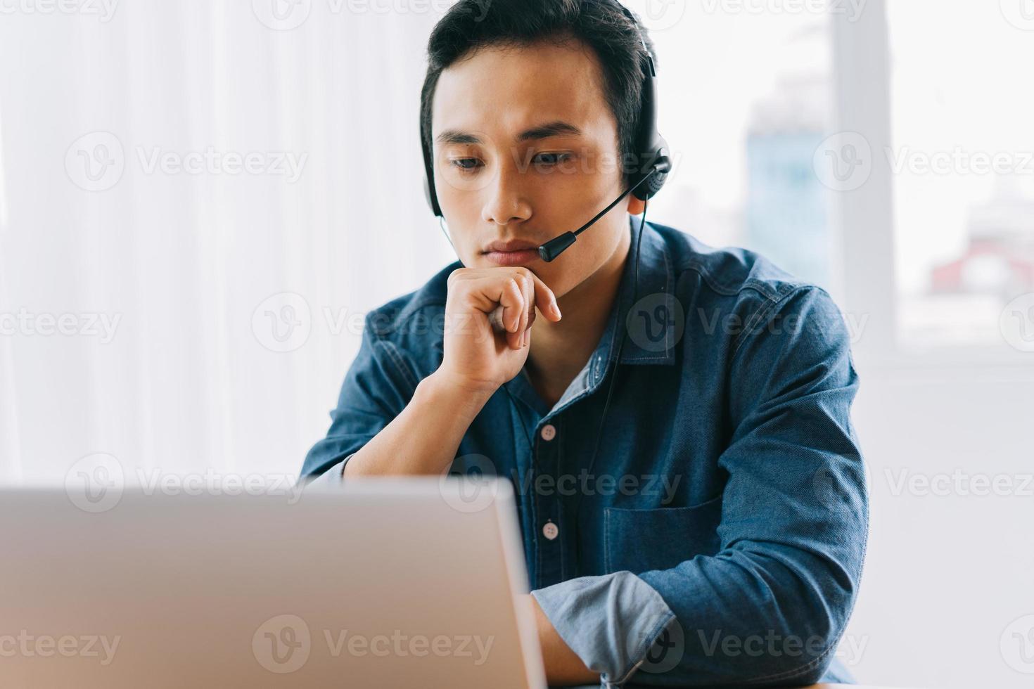The Asian man is having an online discussion with his subordinates photo