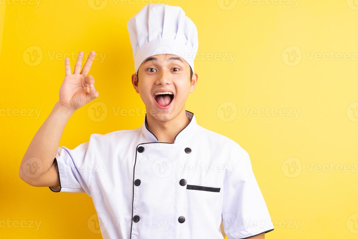 Image of Asian male chef on yellow background photo