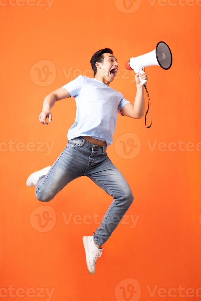 Asian man holding megaphone and shouting photo