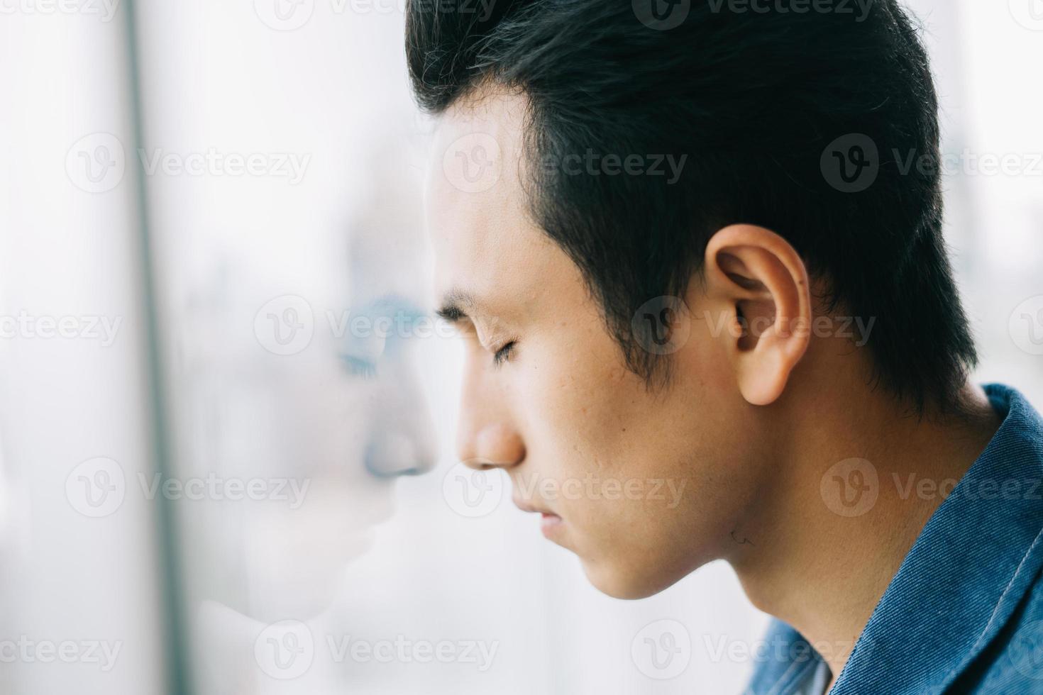 triste, hombre asiático, por la ventana foto