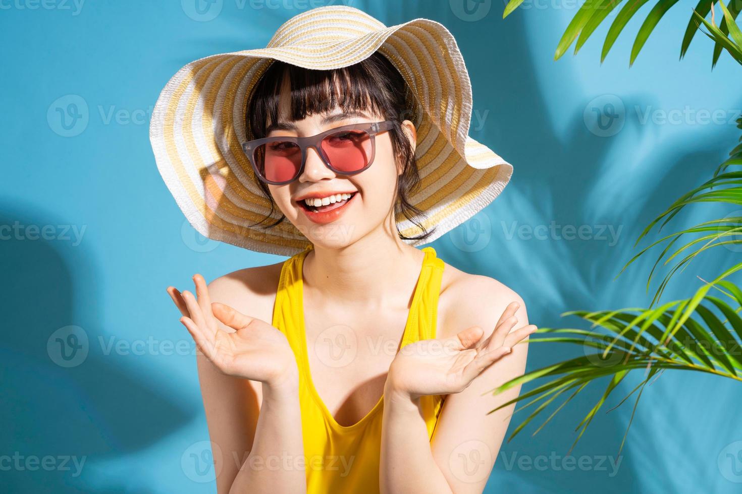Beautiful Asian woman wearing yellow jumpsuit on blue background and, summer concept photo