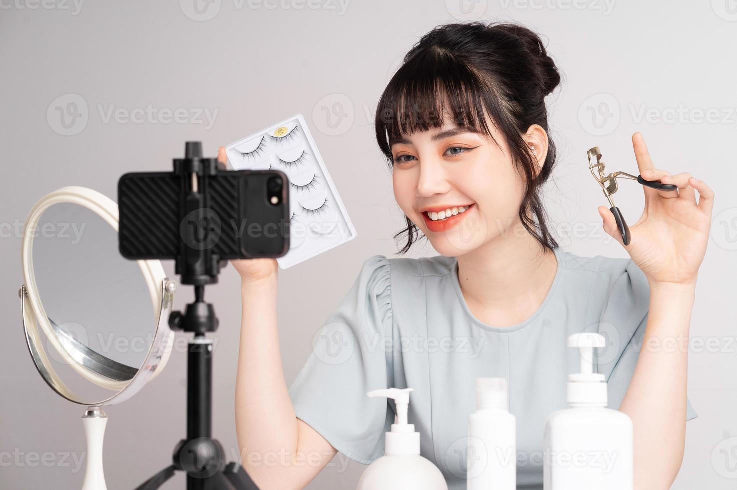 Young Asian woman live streaming to teaching make up online photo