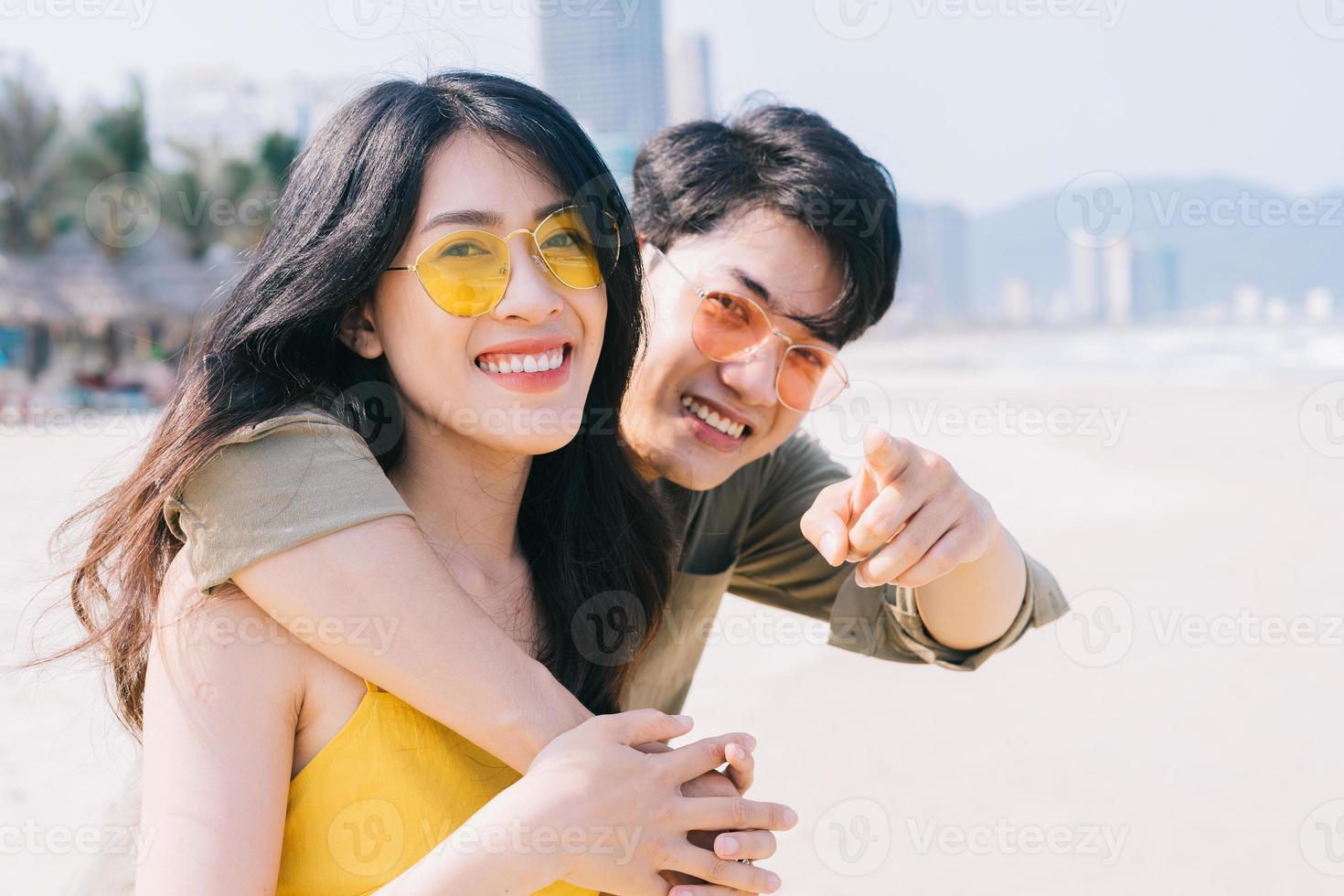 Young Asian couple enjoying summer vacation on the beach photo