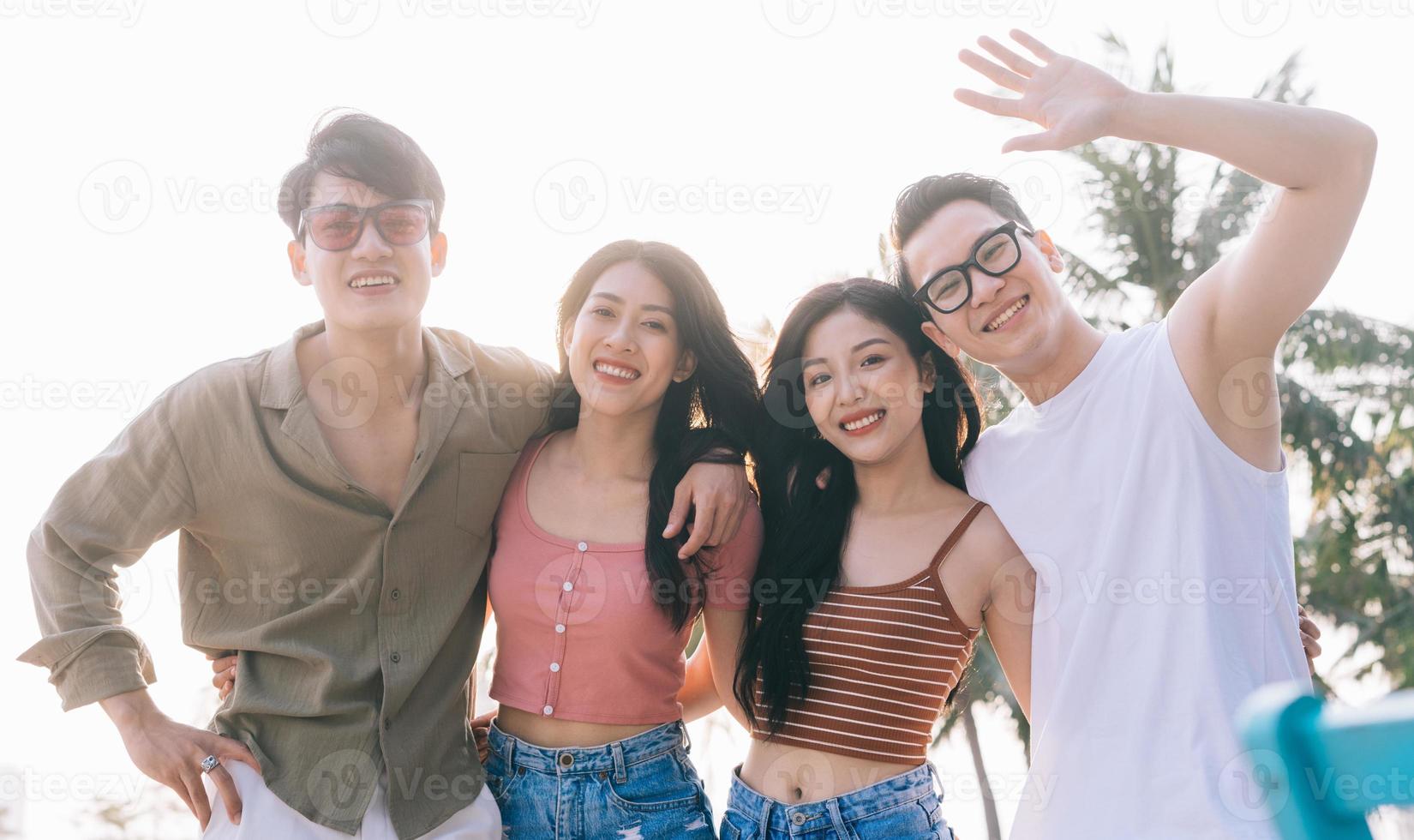 un grupo de jóvenes asiáticos disfrutan de un viaje al mar en unas vacaciones de verano foto