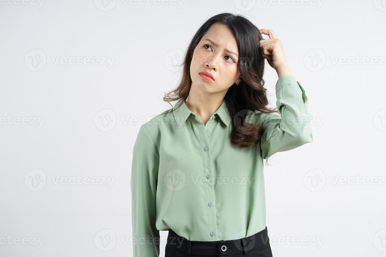 Retrato de la hermosa empresaria asiática rascándose la cabeza con una expresión pensativa foto