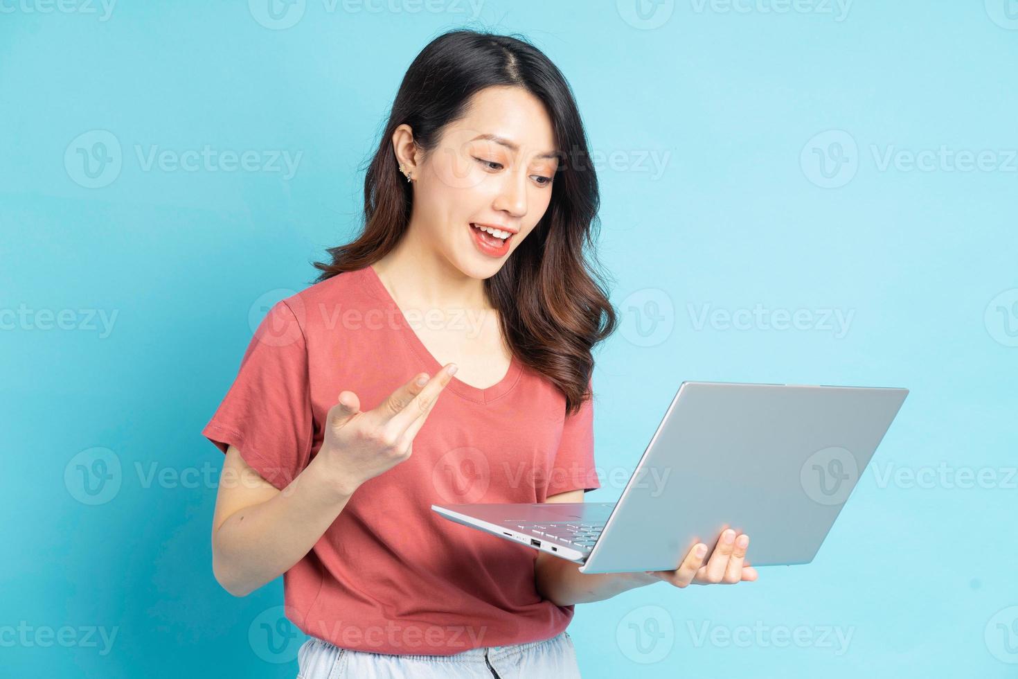 Beautiful Asian woman using laptop to video call with friends photo