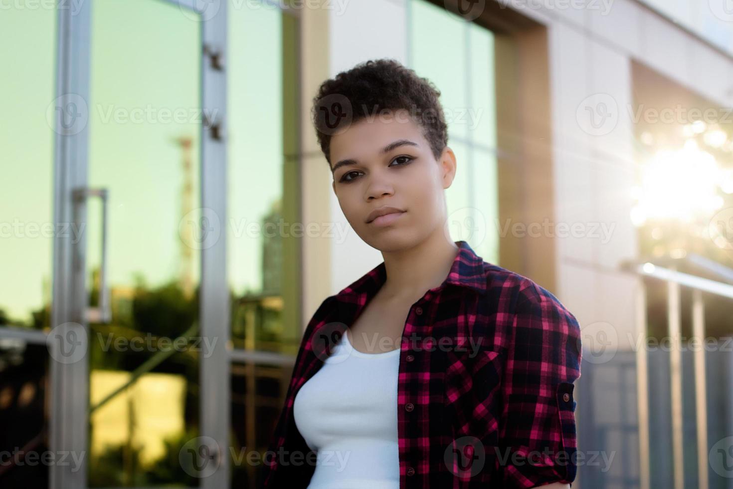 Hermosa mujer afroamericana con pelo corto en el verano en la calle foto