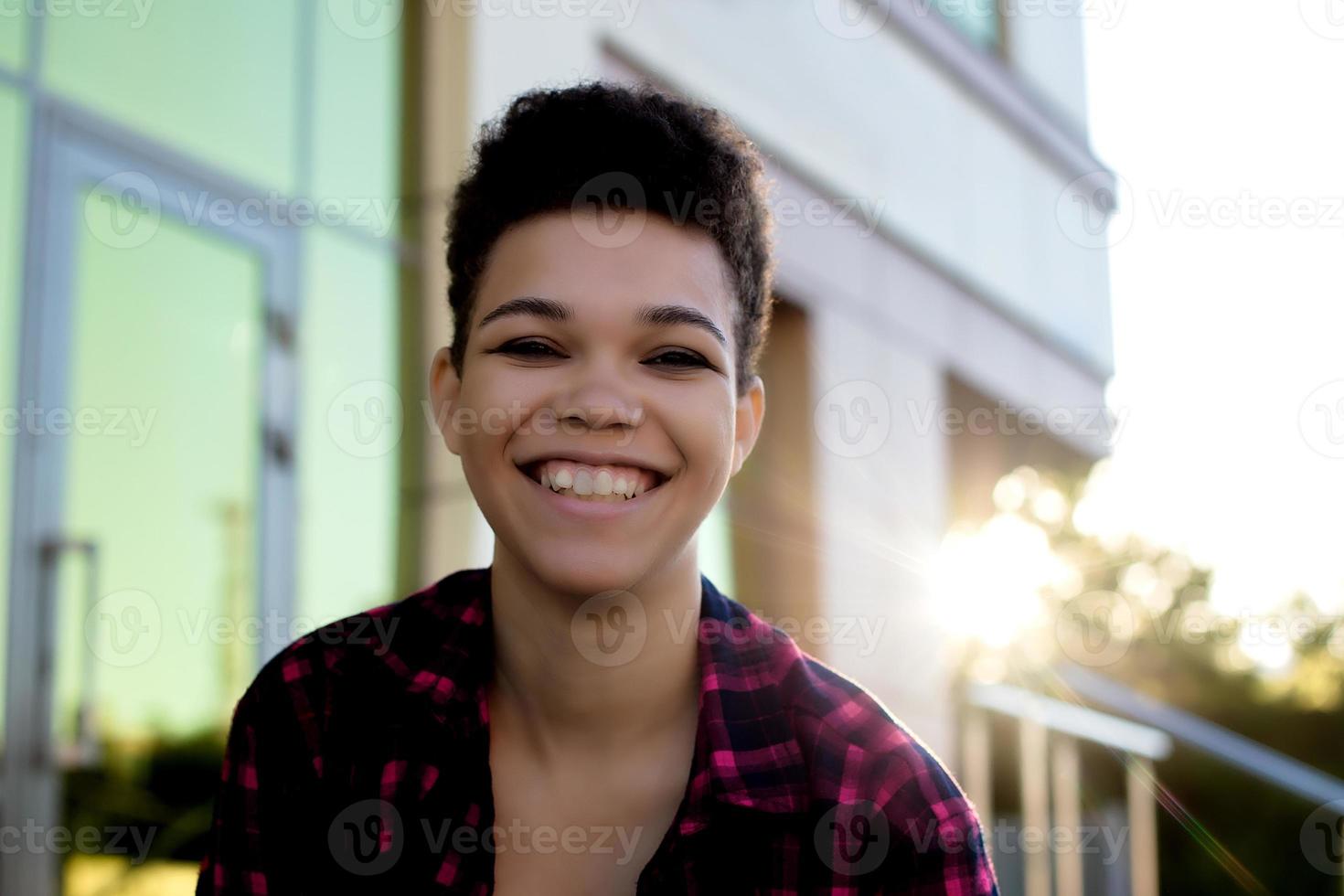 Beautiful African American woman with short hair in the summer on the street photo