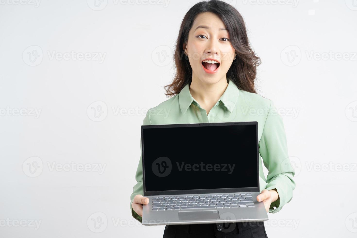 Retrato de una bella empresaria asiática sosteniendo su computadora portátil con una pantalla vacía foto
