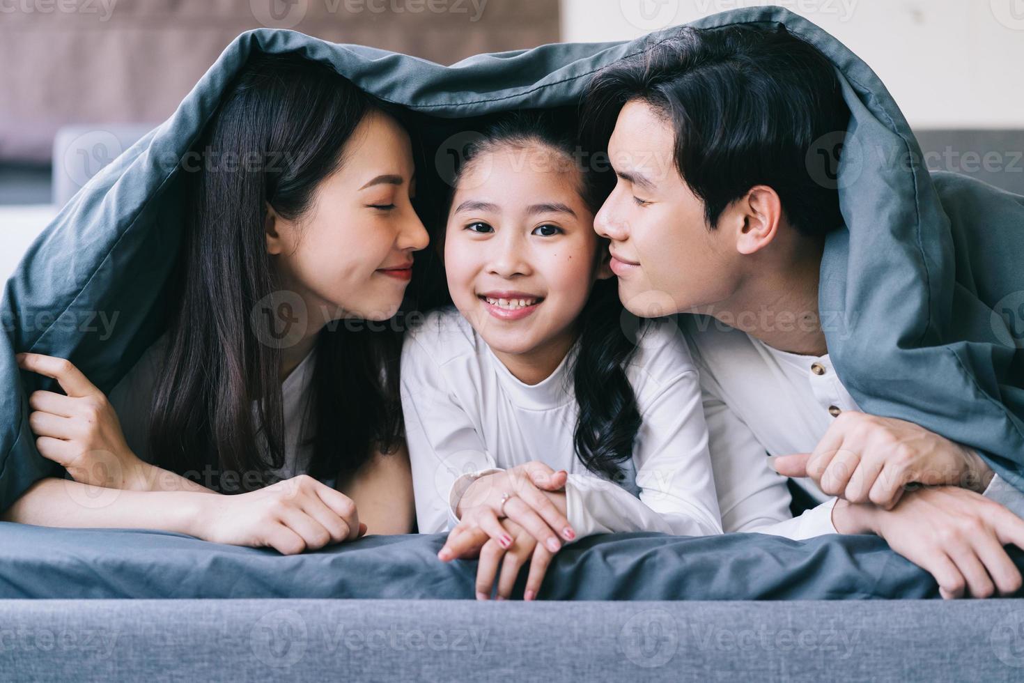 feliz retrato de familia asiática con madre, padre e hija foto