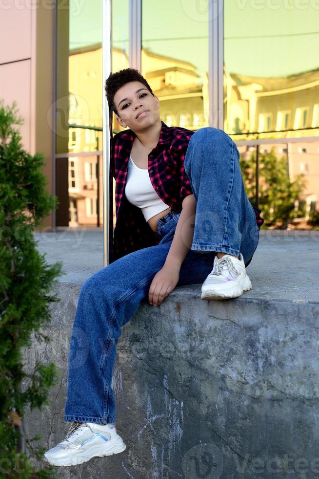 Beautiful African American woman with short hair in the summer on the street photo