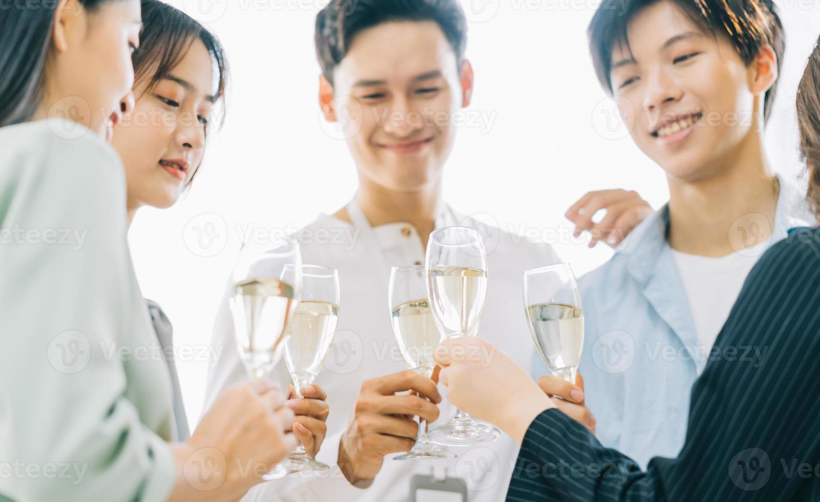 la gente de negocios asiática brinda con sus copas celebrando los resultados foto