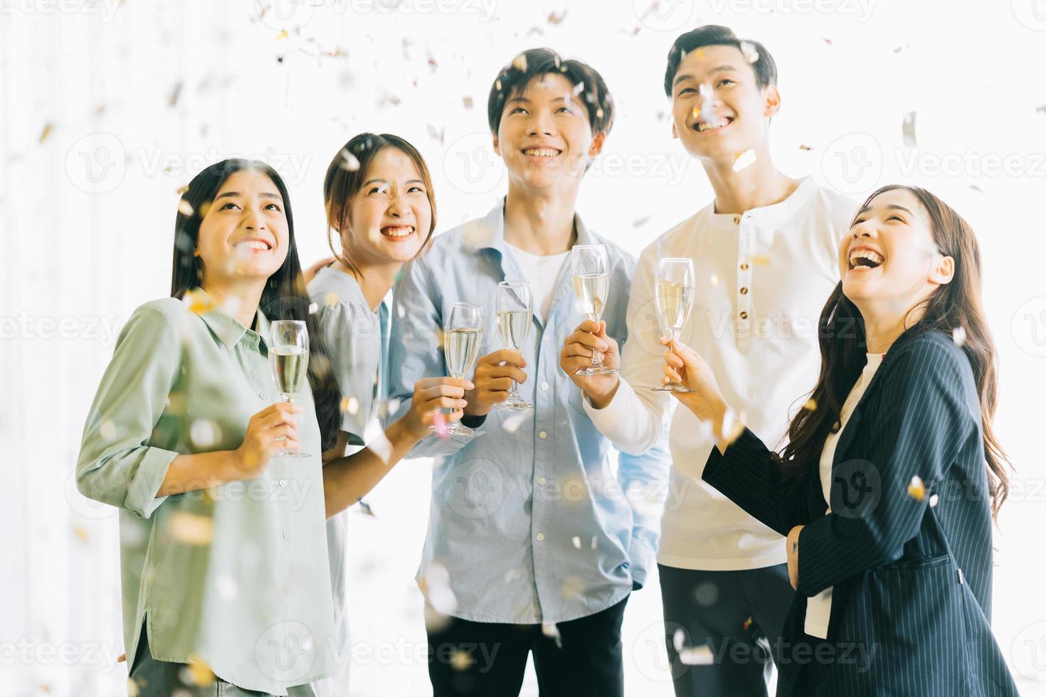 la gente de negocios asiática brinda con sus copas celebrando los resultados foto