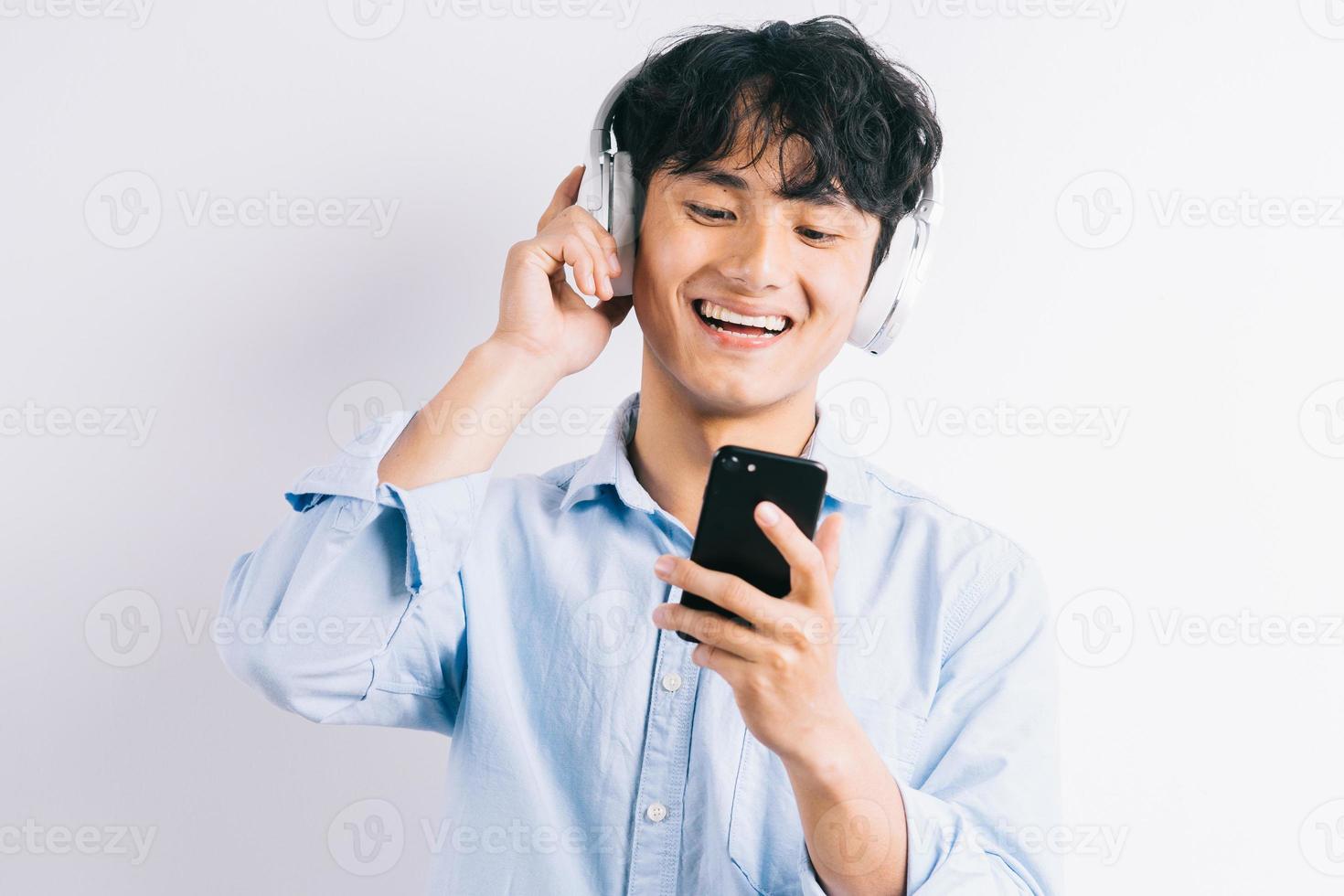 El hombre asiático está escuchando música y repite foto