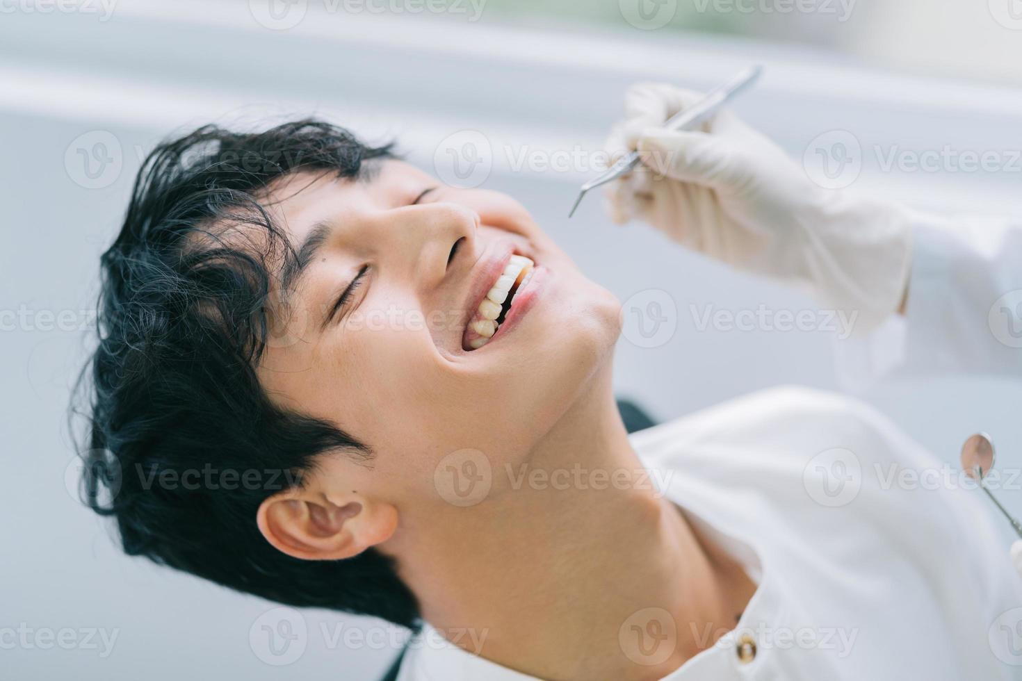 Asian female doctor checking a patient's teeth photo