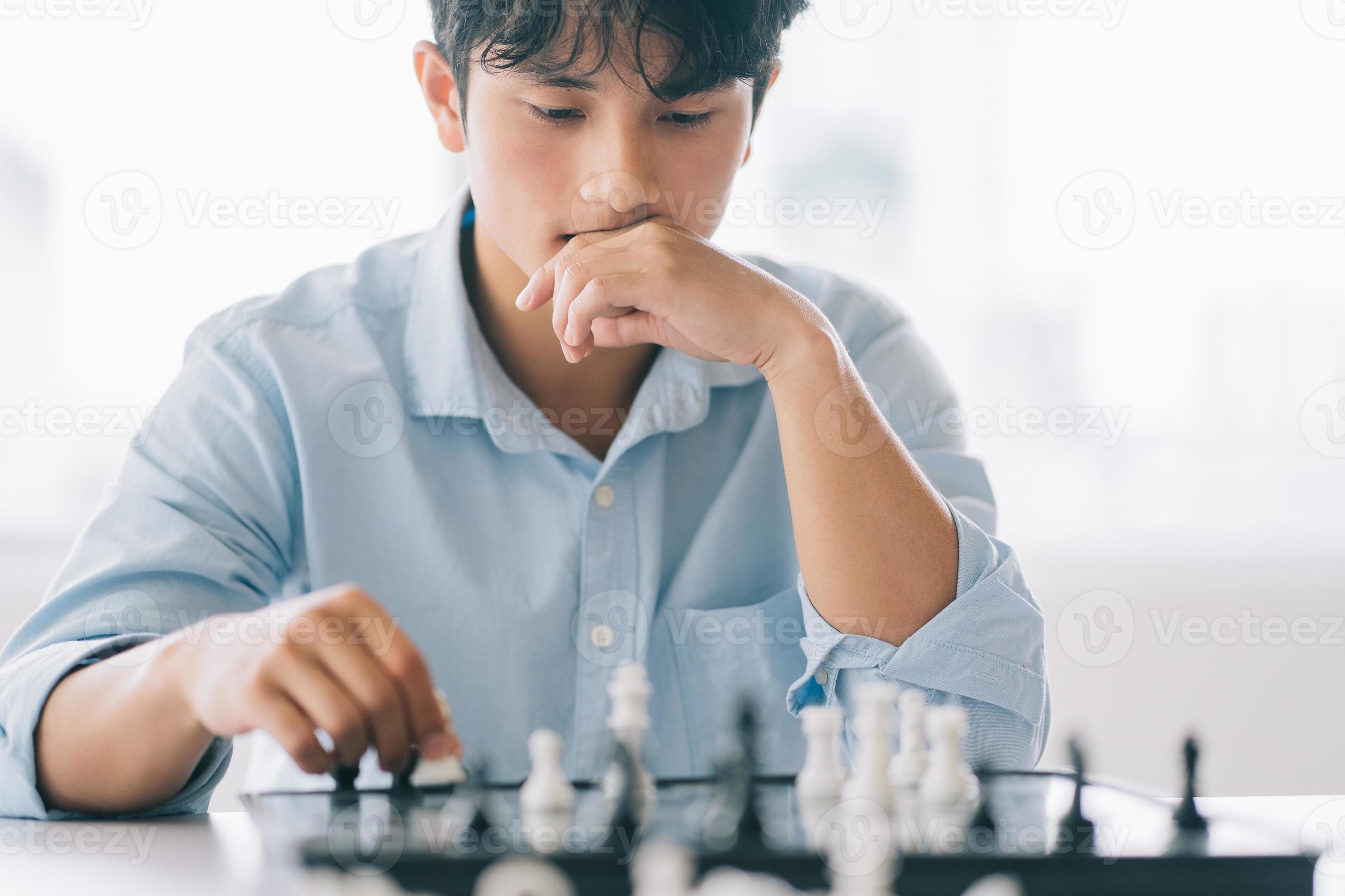 Asian businessman is thinking about his next move on the chess board  2878050 Stock Photo at Vecteezy