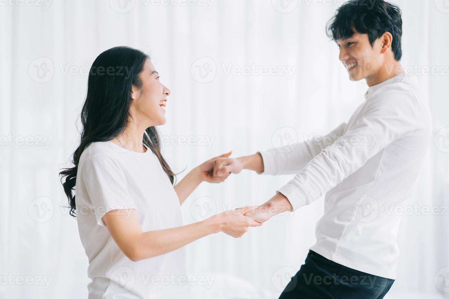 Asian couple dancing together in the bedroom photo